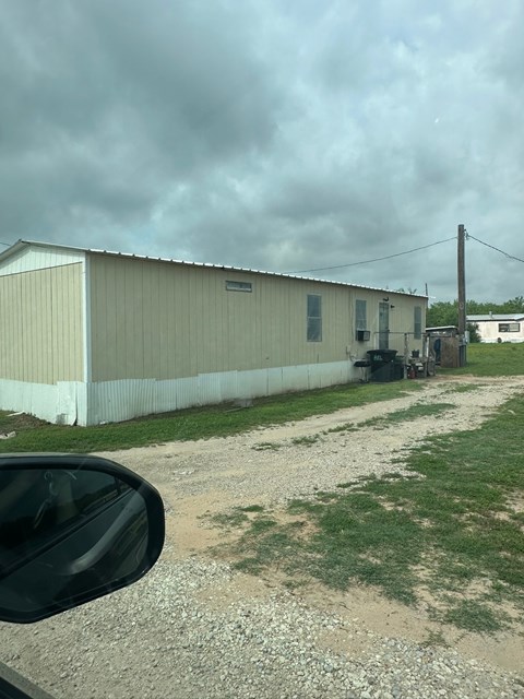 A building with a gravel driveway in front of it.