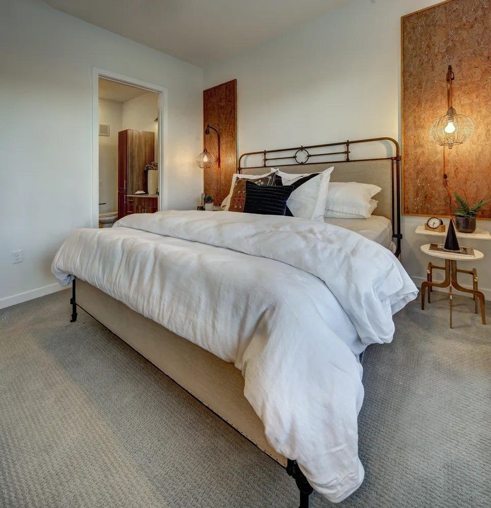 A bedroom with a large bed and a wooden headboard.