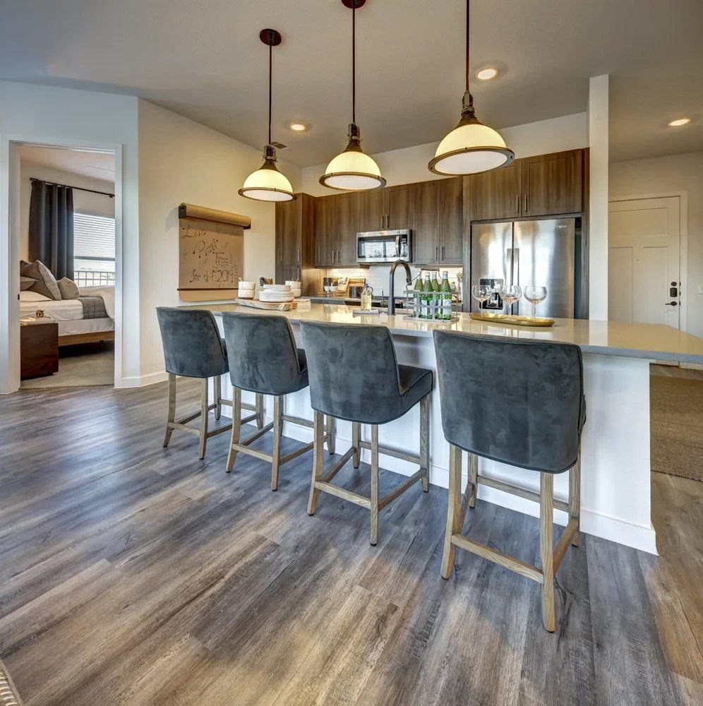 A kitchen with a bar area featuring a long counter and bar stools.