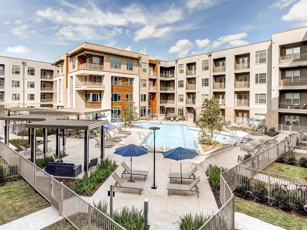 A large apartment complex with a pool and patio area.