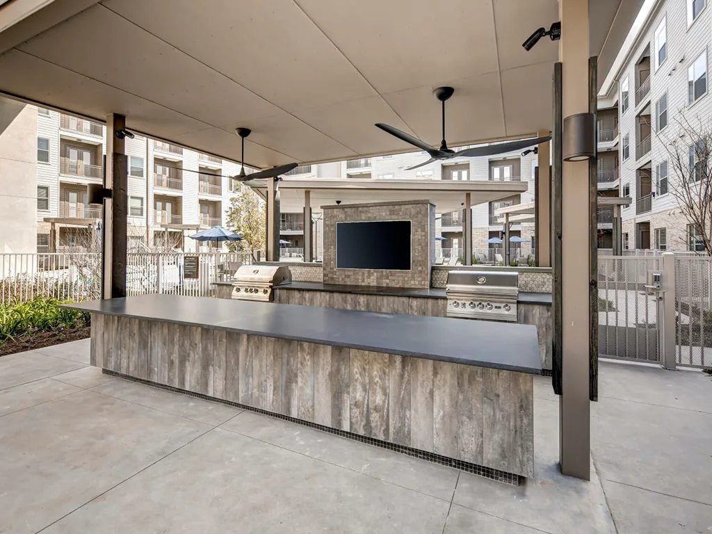 A modern outdoor kitchen with a grill and oven.