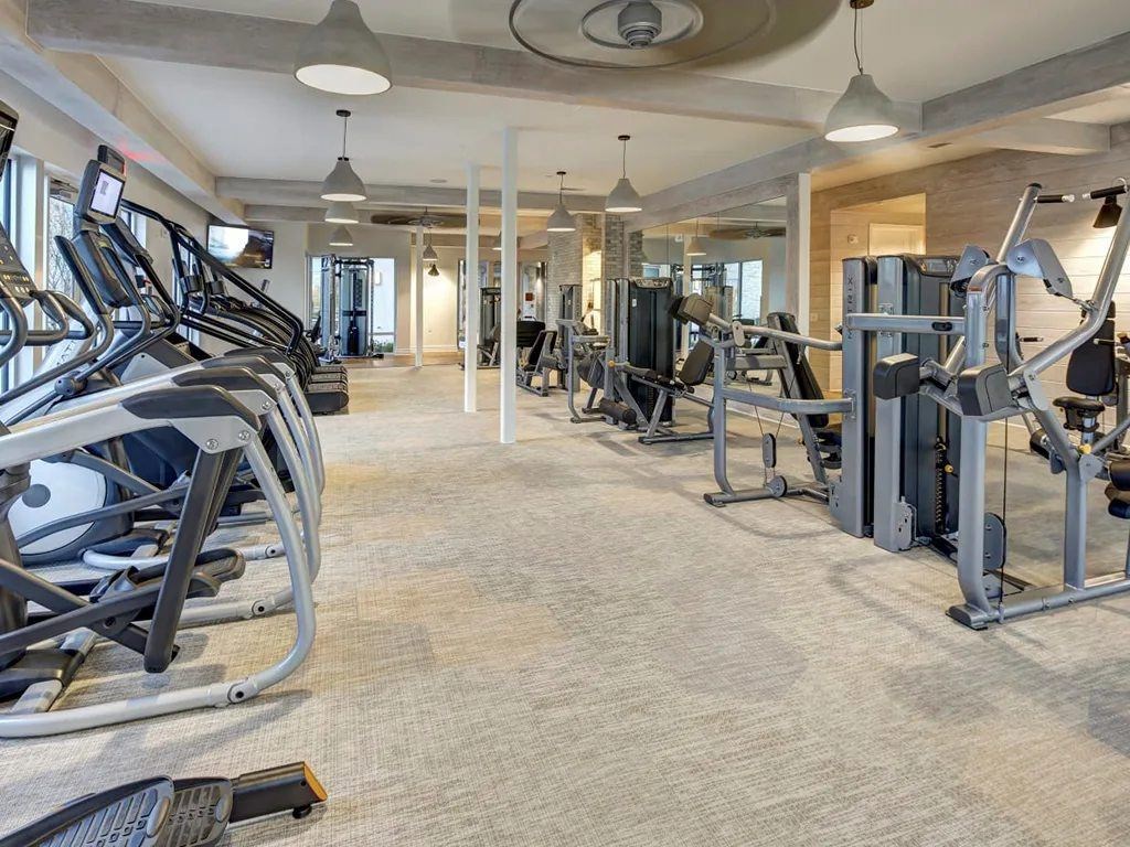A spacious gym with treadmills, elliptical machines, and other exercise equipment.