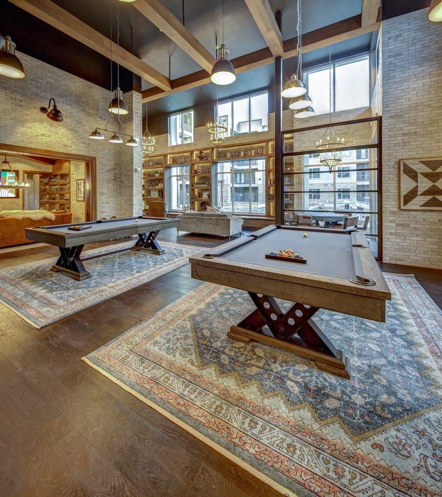 A room with a pool table and a rug.
