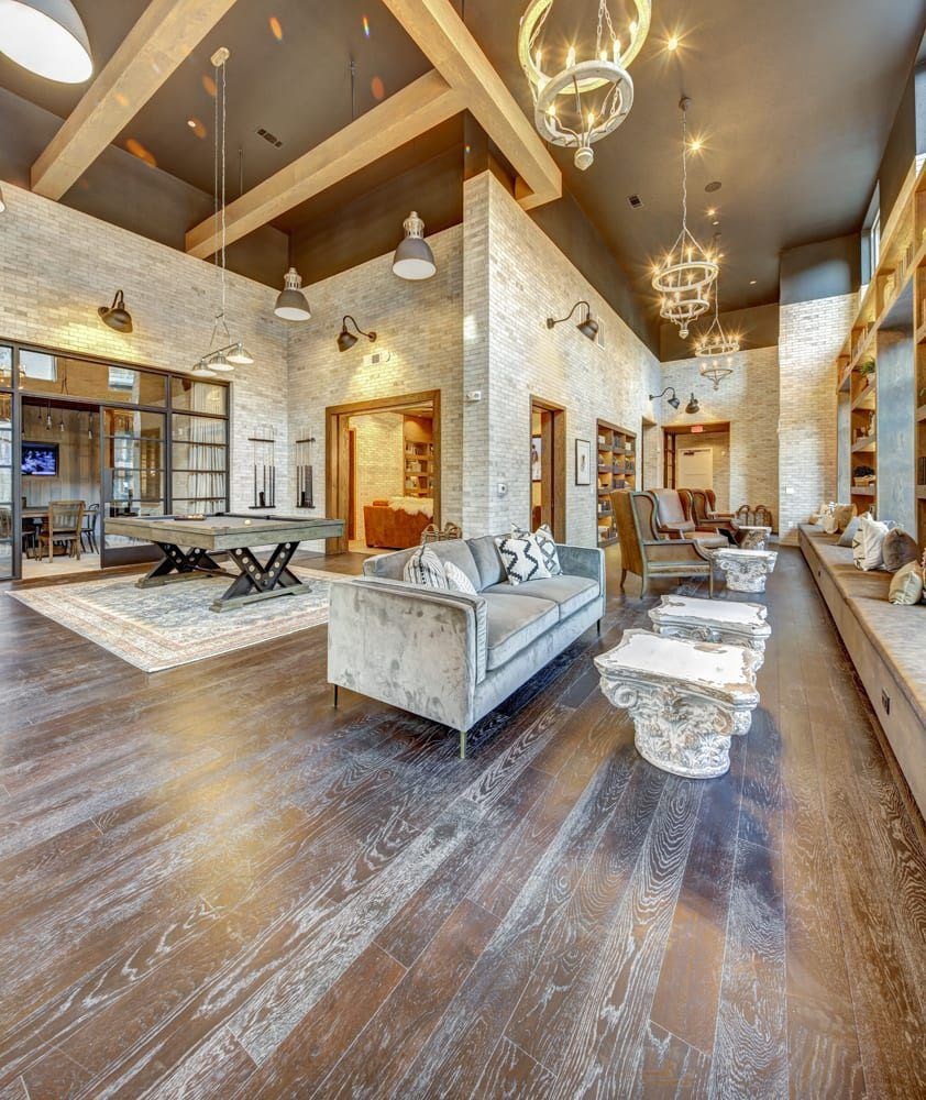 A living room with a white brick wall and wooden floors.