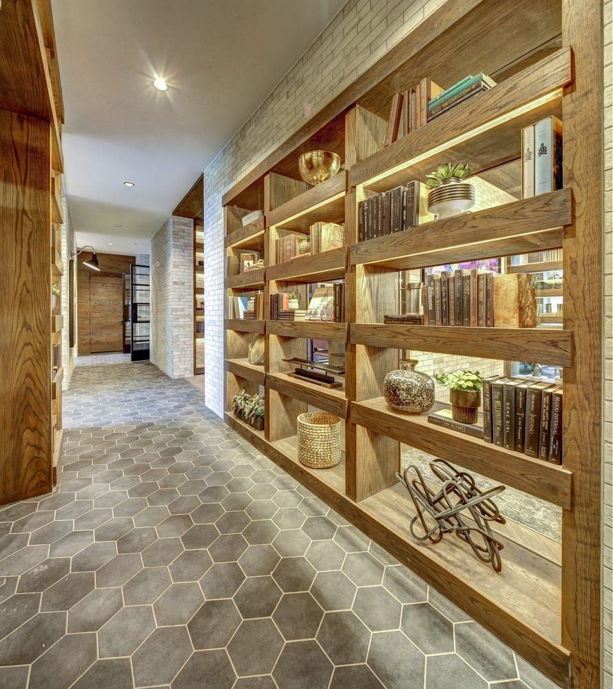 A long hallway with a shelf on the wall.