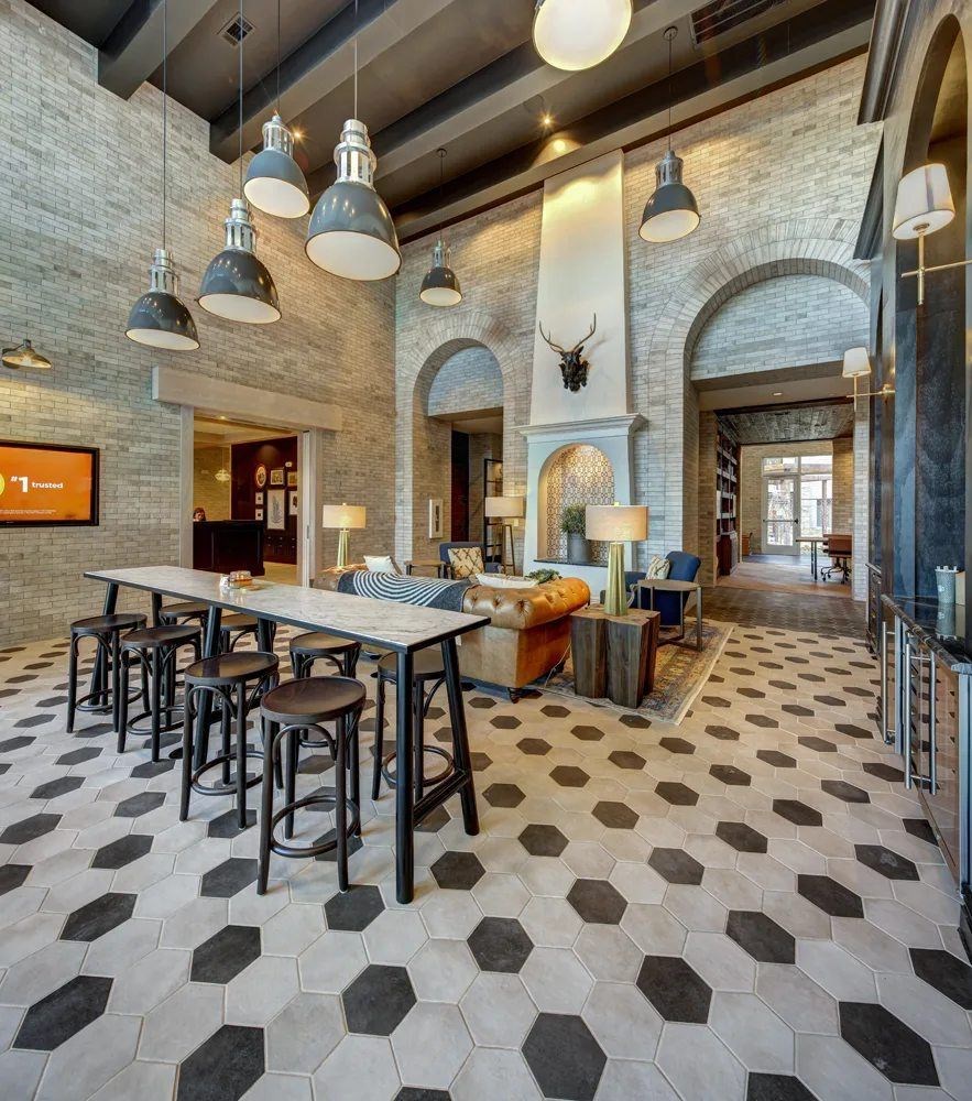 A room with a long table and chairs with a black and white floor.