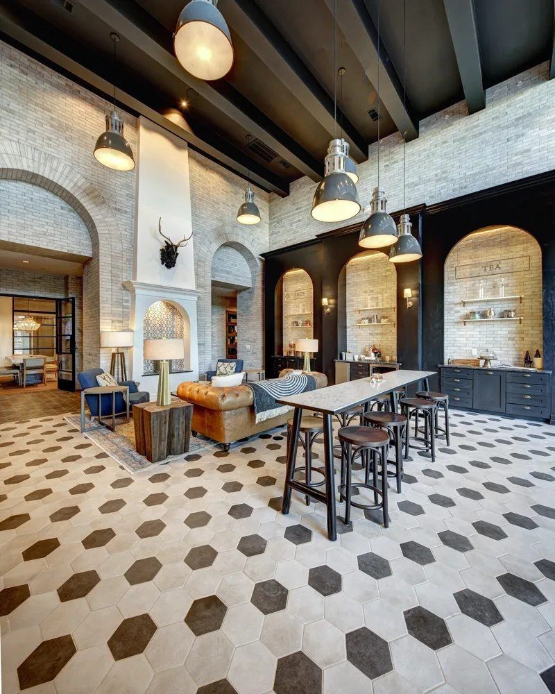 A large open space with a patterned floor and a bar area.