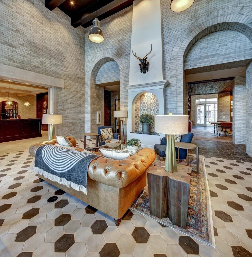 A large bedroom with a large bed and a stone wall.