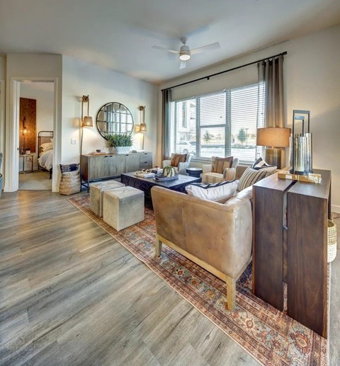A living room with a brown leather couch and a rug.
