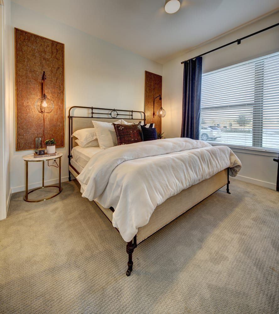 A bedroom with a large bed and a wall hanging.