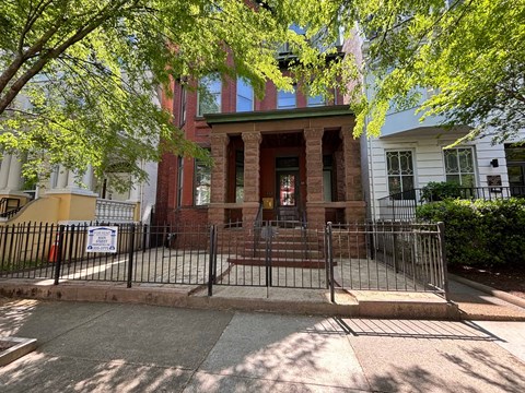 A red brick building with a black gate in front.