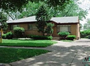 A house with a brown roof and a green lawn in front.