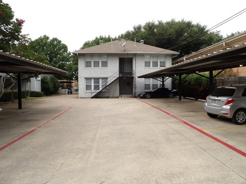 A white house with a grey car parked in front.