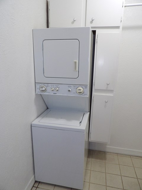 A small white washing machine in a laundry room.