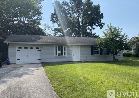A house with a garage and a driveway is for sale.