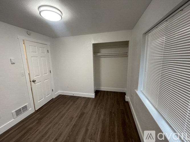 A room with a white door and a window with blinds.