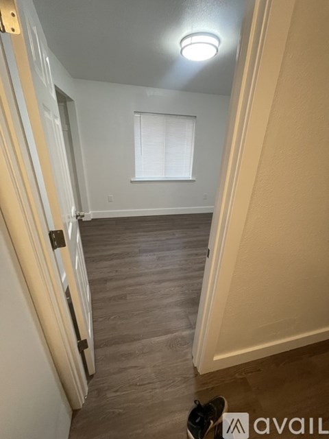 A hallway with a wooden floor and a white door.