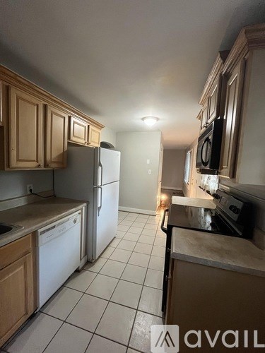 A kitchen with wooden cabinets and a white refrigerator.