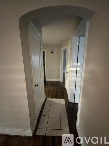 A hallway with a tiled floor and white walls.