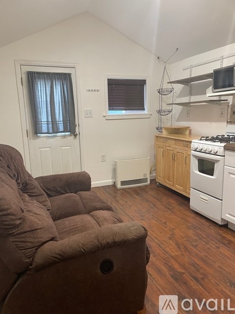 A living room with a brown couch and a white stove.