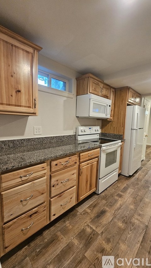 A kitchen with wooden cabinets and a granite countertop.
