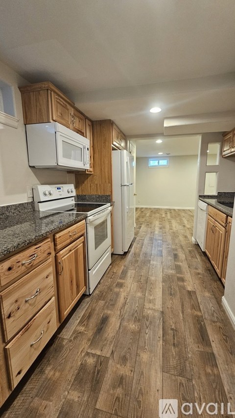 A kitchen with wooden floors and white appliances.