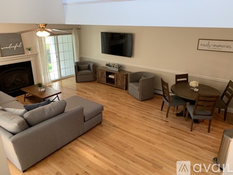 A living room with a grey sofa and a wooden floor.
