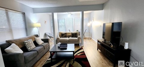 A living room with a grey couch and a black coffee table.