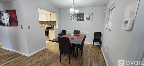 A dining room with a table and chairs.