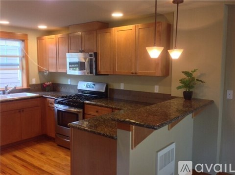 A kitchen with wooden cabinets and granite countertops.