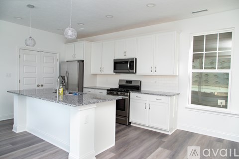 A kitchen with white cabinets and a granite countertop.