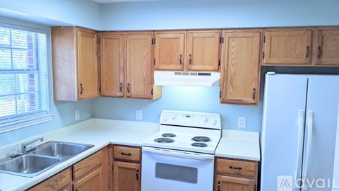 A kitchen with wooden cabinets and white appliances.
