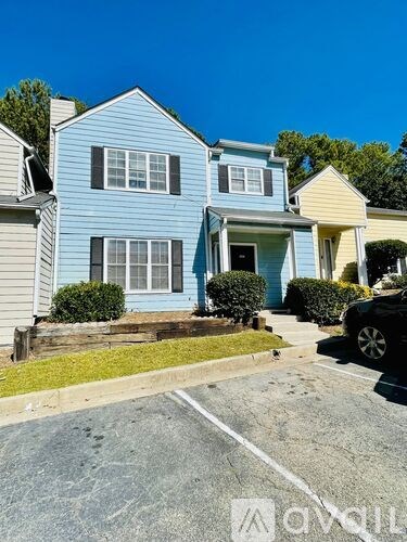 A blue house with a white car parked in front.