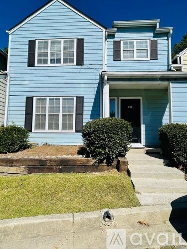 A blue house with a black door and windows.