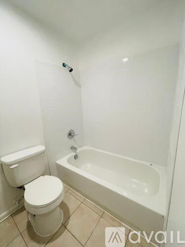 A white toilet sits next to a bathtub in a bathroom.