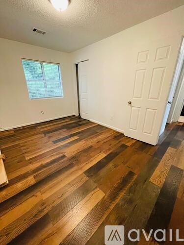 A room with wooden flooring and a white door.