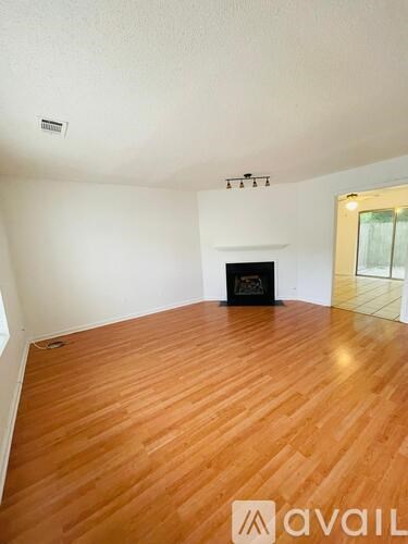 A room with a wood floor and a fireplace.