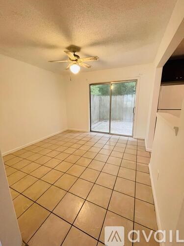 A room with a ceiling fan and tiled floor.