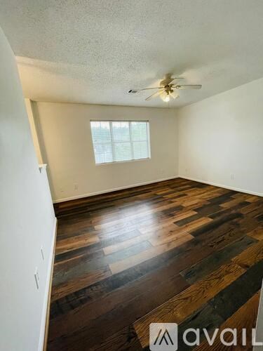 A room with wooden floors and a ceiling fan.