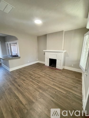 A room with a fireplace and wooden flooring.