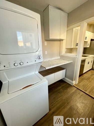 A white oven and microwave in a kitchen with wooden floors.