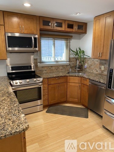 A kitchen with wooden cabinets and granite countertops.