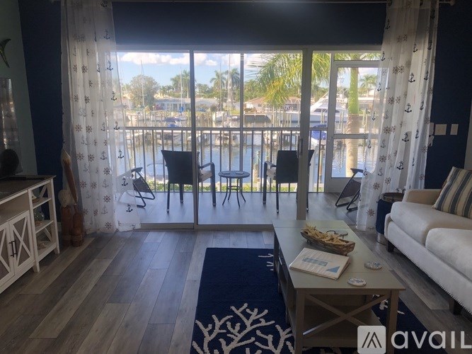 A living room with a view of the water and boats outside the window.