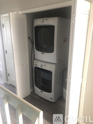 A white oven and microwave are stacked on top of each other in a kitchen.
