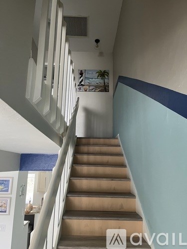 A staircase with a blue stripe on the wall.