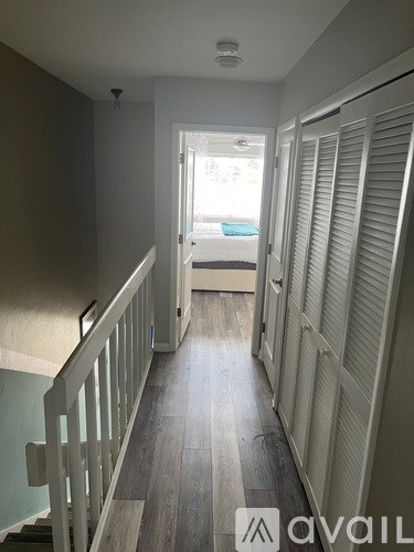 A hallway with a staircase on the left and a door on the right.