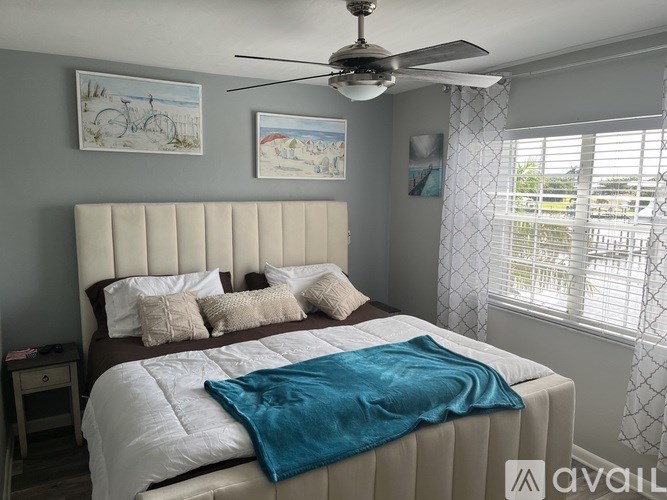 A bedroom with a large bed and a ceiling fan.