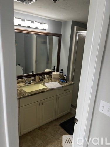 A bathroom with a sink, mirror, and cabinets.