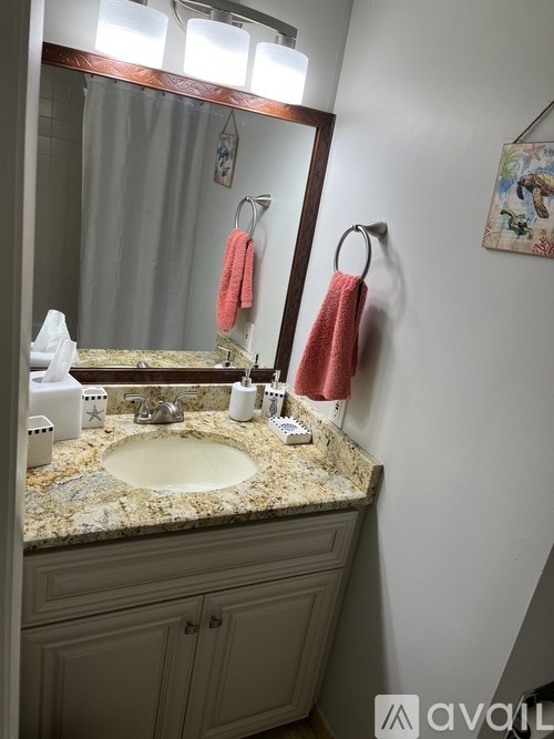 A bathroom with a sink, mirror, and towel rack.