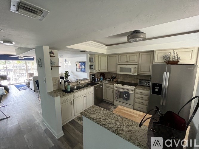 A kitchen with a refrigerator, microwave, and oven.